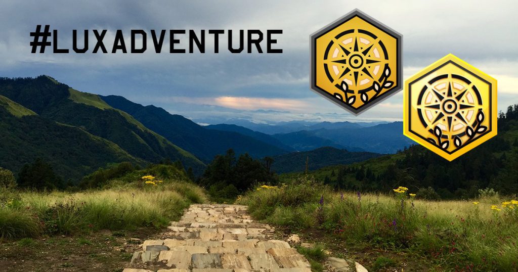 #LUXADVENTURE - path going down through lush green mountainside with the iconic yellow and gold luxadventure badges overlayed